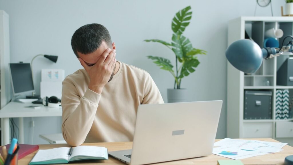 Frustrated office worker overwhelmed at a slow laptop computer