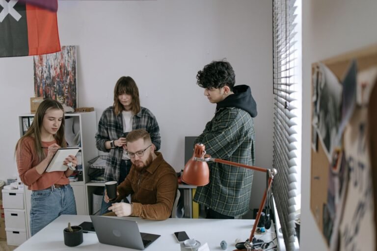 Small office team meeting around a laptop
